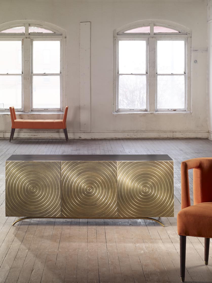 The Eliza Chair shown in Marmalade Velvet sits in a rustic room with a mid-century modern sideboard.