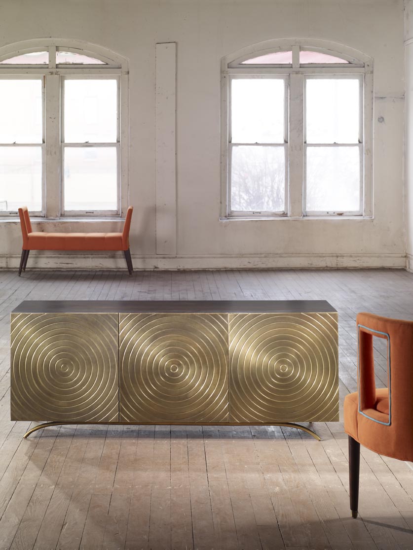 The Eliza Chair shown in Marmalade Velvet sits in a rustic room with a mid-century modern sideboard.