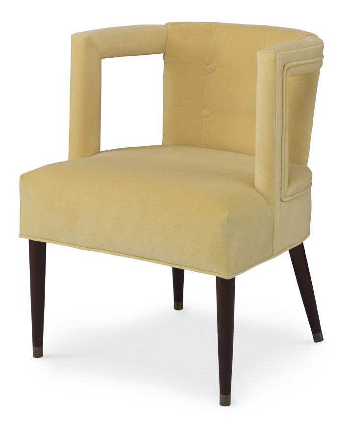 The Eliza Chair shown in Turmeric Velvet sits in a studio.