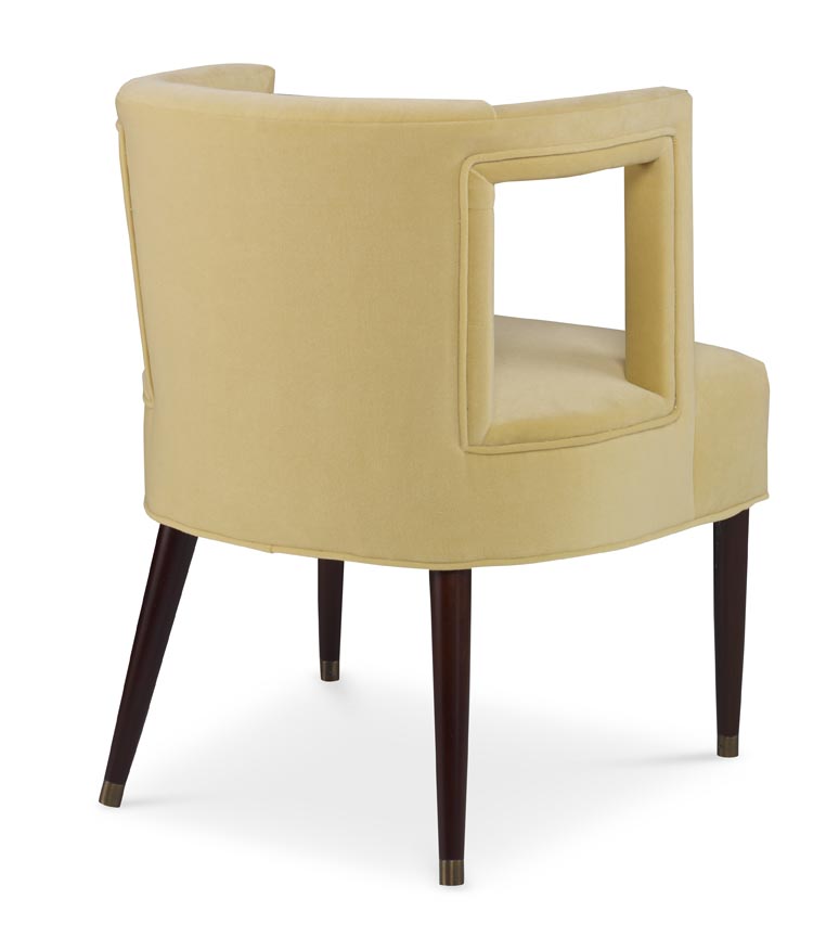 The Eliza Chair shown in Turmeric Velvet sits in a studio.