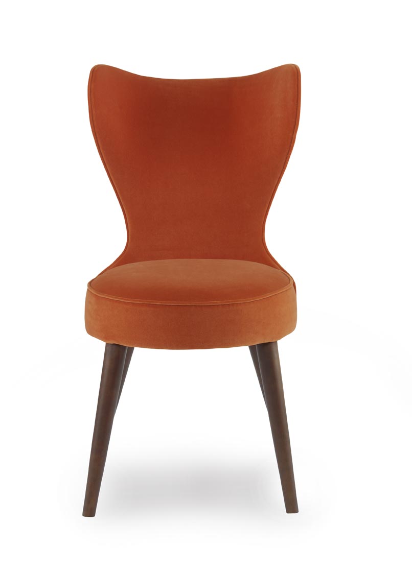 The Maribella Chair in Marmalade Velvet with Custom COM back sits in a studio.
