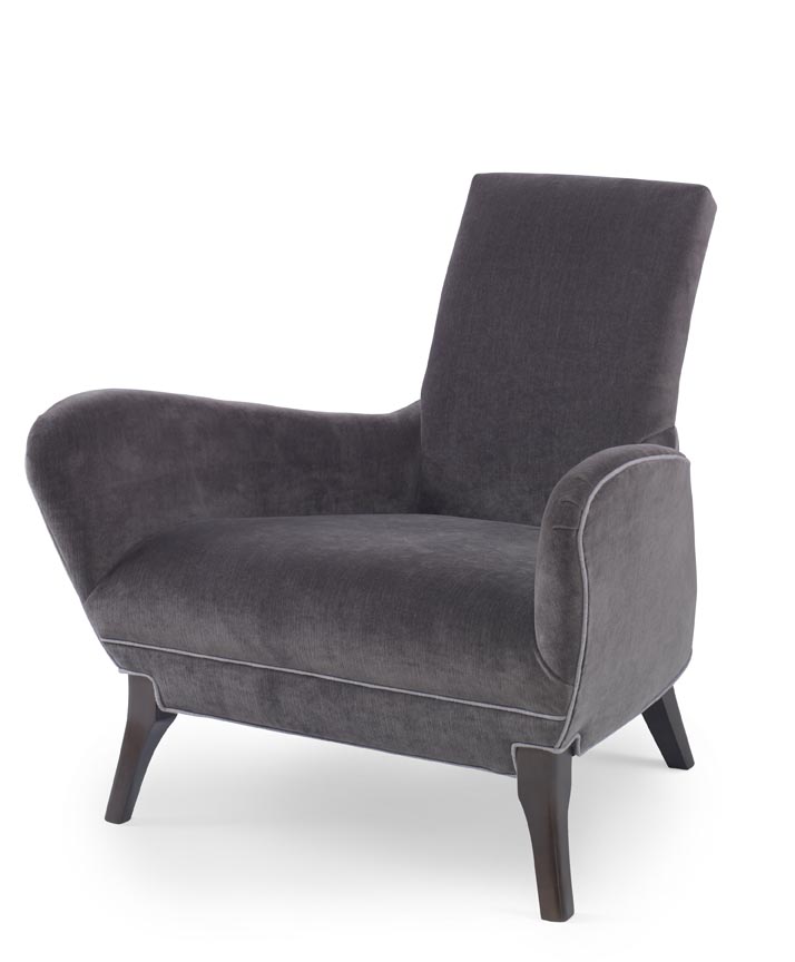 The Naomi Chair in Dark Grey Velvet with Dark Maple Finishes sits in a studio.