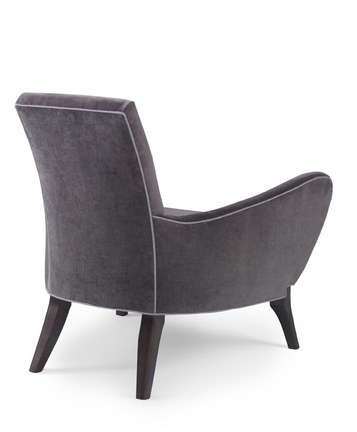 The Naomi Chair in Dark Grey Velvet with Dark Maple Finishes sits in a studio.