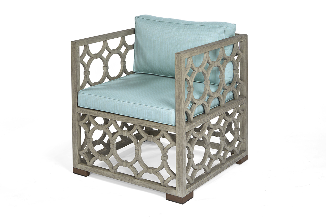 The Wolfgang Arm Chair in European Mid Oak and Glacier Linen with Aged Brass Feet sits in a studio.