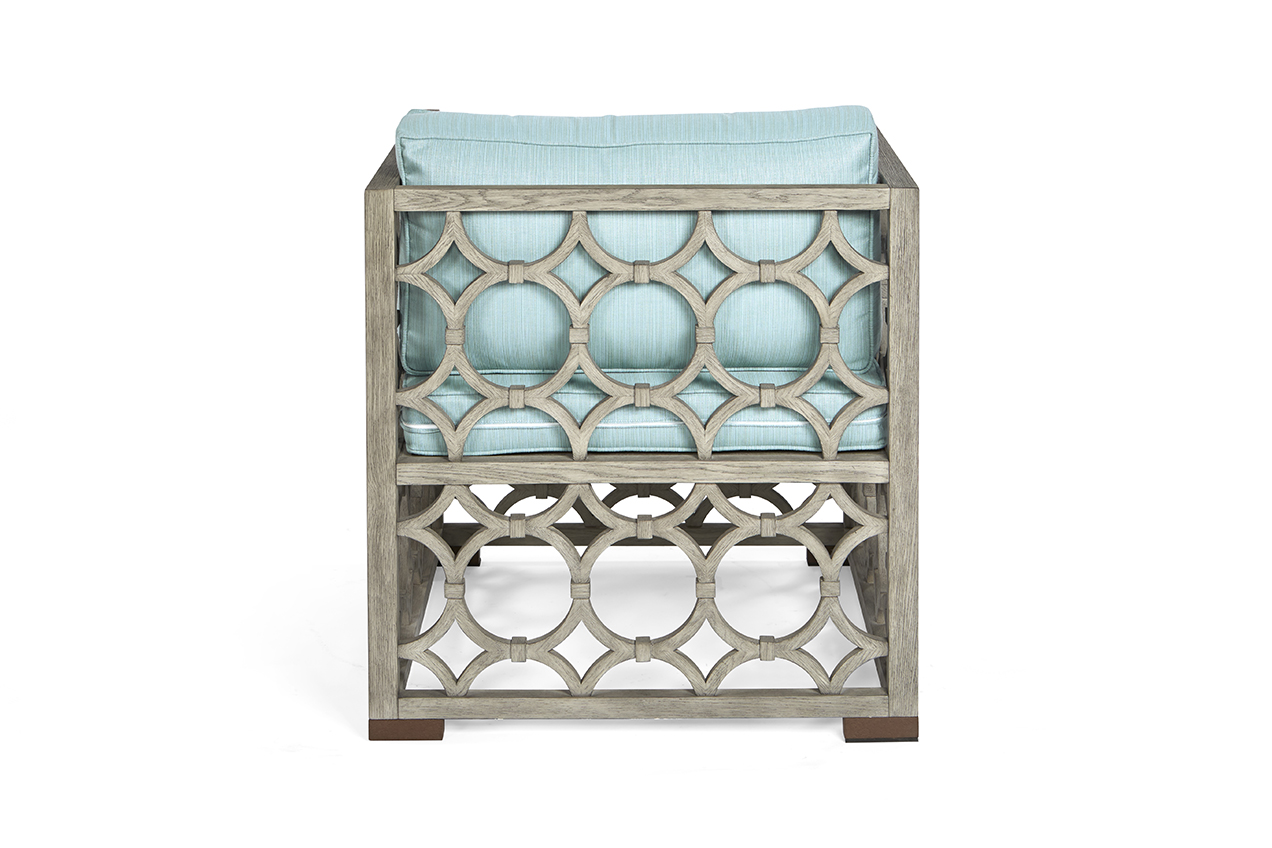 The Wolfgang Arm Chair in European Mid Oak and Glacier Linen with Aged Brass Feet sits in a studio.