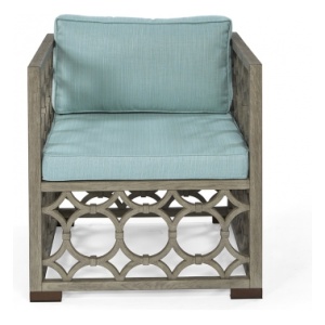 The Wolfgang Arm Chair in European Mid Oak and Glacier Linen with Aged Brass Feet sits in a studio.